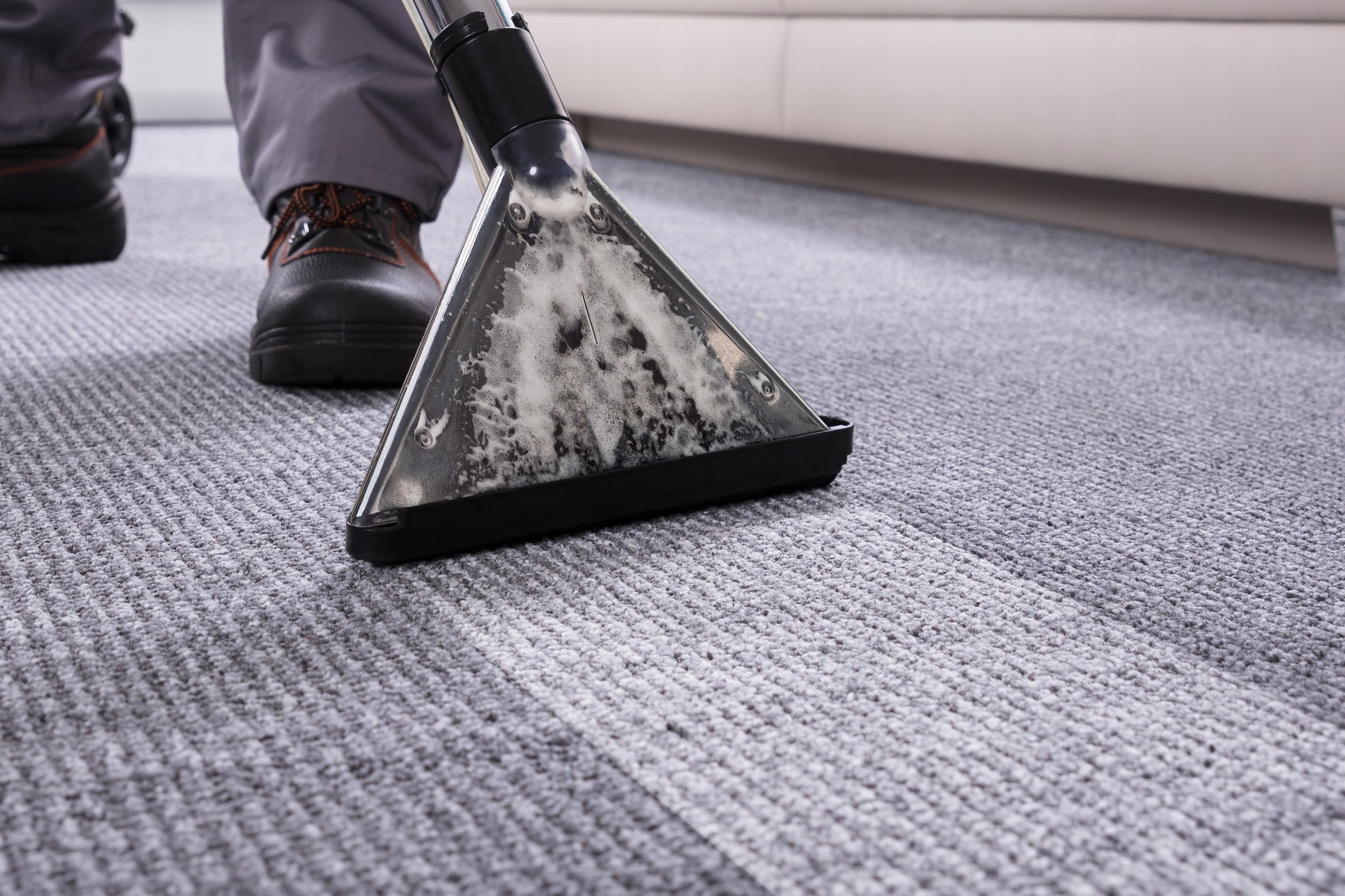 Person Cleaning Carpet With Vacuum Cleaner